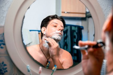 Genç adamın yüzü banyoda tıraş bıçağı kullanıyordu.