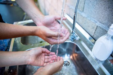 Hijyen konsepti. Musluğun altında sabunla ellerini suyla yıkamak. Bakteri ve virüs mikroplarından temizleme
