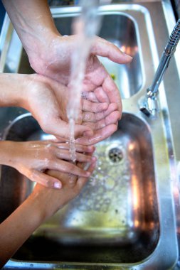 Hijyen konsepti. Musluğun altında sabunla ellerini suyla yıkamak. Bakteri ve virüs mikroplarından temizleme