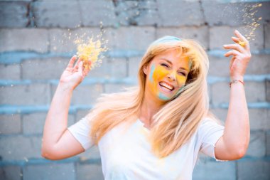 Geleneksel Hint festivali için Holi renkleri olan kadın. Yüzüne Holi pigmenti tozu sıçratan bir kız. Dışarıda dans eden mutlu kadın.