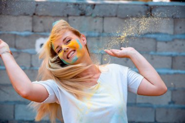 Geleneksel Hint festivali için Holi renkleri olan kadın. Yüzüne Holi pigmenti tozu sıçratan bir kız. Dışarıda dans eden mutlu kadın.