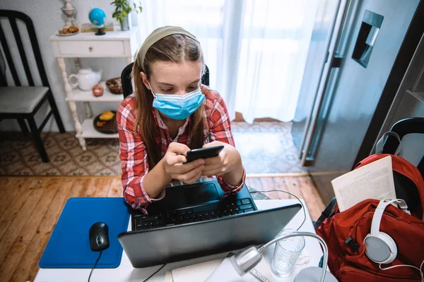 Genç Kız online eğitim başvurusu için dizüstü bilgisayar kullanıyor. Coronavirus salgını sırasında evdeki video sınıfındaki çocuk