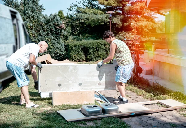 Men moving house and delivery furniture  in the backyard. Carrying furniture and unpacking truck. Men moving to new real estate rental home. Copy space