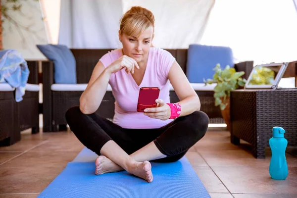 현명한 모바일 사용하고 식생활 칼로리를 계산하여 집에서 운동하는 성있는 여자의 — 스톡 사진