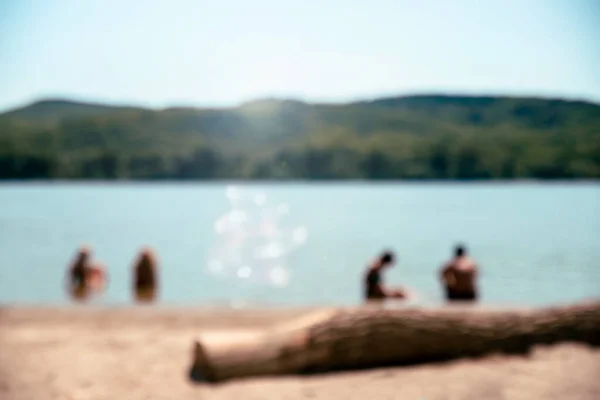 Blurred beach with people relaxing in the water. Summer vacation background