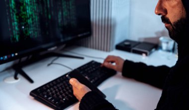 Kapüşonlu Adam bilgisayarını, bilgisayarını ve cep telefonunu kullanarak dijital saldırı güvenlik sistemini kullanıyor. Geceleyin Erkek Hackleme, veri çalmak ya da internet arayüzünü kırmak. Seçici odak