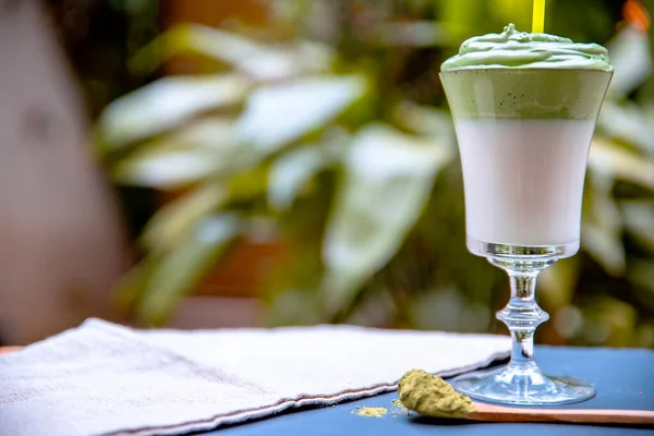 Green matcha frothy drink with vegan cream. Dalgona coffee break. Dessert healthy frappe refreshing cold iced drink with green tea and whipped cream