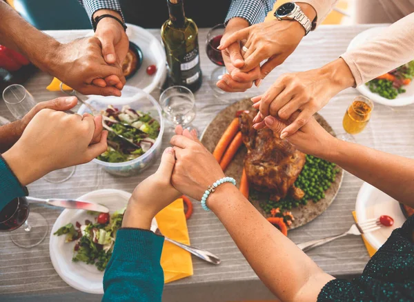 Şükran Günü yemeğinde el ele tutuşup dua etmek. Yemekler için şükran dolu bir aile. Şenlik yemeğinden önce dua ediyorum.