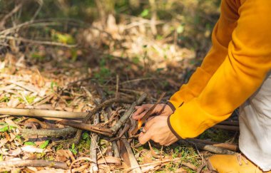 Kadın sonbahar ormanlarında ateş yakar, doğada yiyecek ısıtmaya hazırlanır, kendini ateşle ısıtır. Macera, hayatta kalma kavramı.