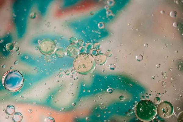 macro of olive oil drops on water as abstract background