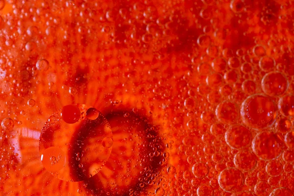 macro of olive oil drops on water as abstract background