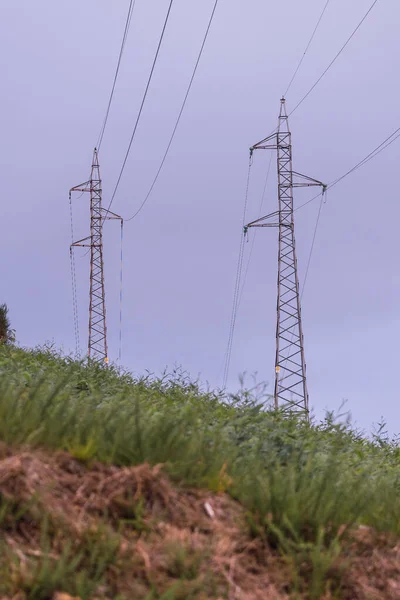 Electric pole and cables. An old overhead power line and a single metal utility pole structure. Electric power transmission and distribution cables. Vintage style with copy space.