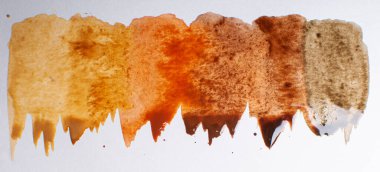 Beyaz kağıt üzerinde taze taze kahverengi suluboya damlaları