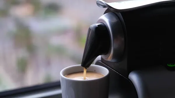 Primer plano de una máquina de café vertiendo un expresso en una taza. — Foto de Stock
