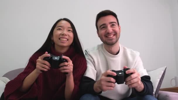 Joven pareja multirracial divirtiéndose jugando videojuegos. — Vídeos de Stock