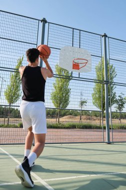 Basketbolcu topu potaya atıyor..