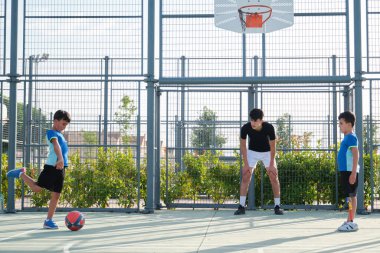 Koltuk iki öğrenciyle futbol oynuyor..