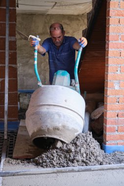 İnşaatçı beton karıştırıcıdan radyan zemine beton döküyor..