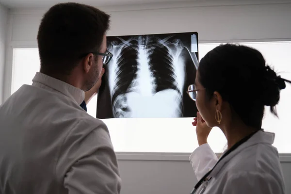 Dos doctores estudiando una imagen de rayos X de costillas. —  Fotos de Stock