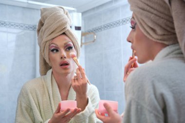 Duştan sonra yanaklarına allık süren travesti..