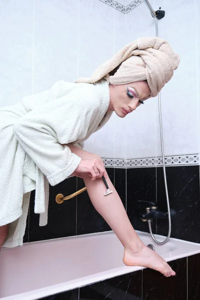 Sürüklenen kraliçe duş kabininde jiletle bacaklarını tıraş ediyor..