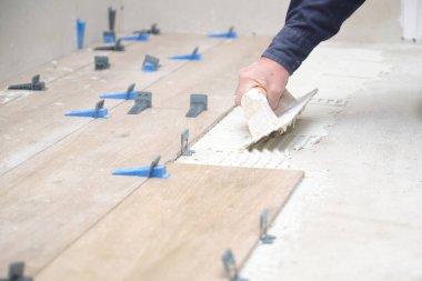 Tanımlanamayan mason fayansları yere çentik şeklinde bir malayla yapıştırıyor..