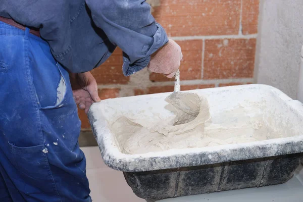 Trabalhador construtor sênior irreconhecível preparando argamassa adesiva de azulejo. — Fotografia de Stock