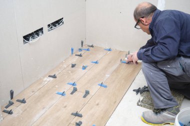 Seramik ahşap döşeme ustası fayans döşeme kiremitleri kullanıyor..