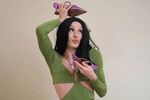 Portré egy drag queen személy pózol holding sarok bézs háttér. — Stock Fotó