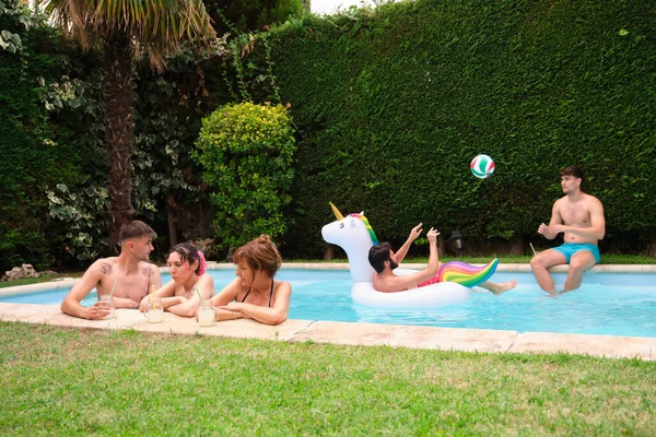 Grupp människor som dricker lemonad och har roligt i en pool. — Stockfoto
