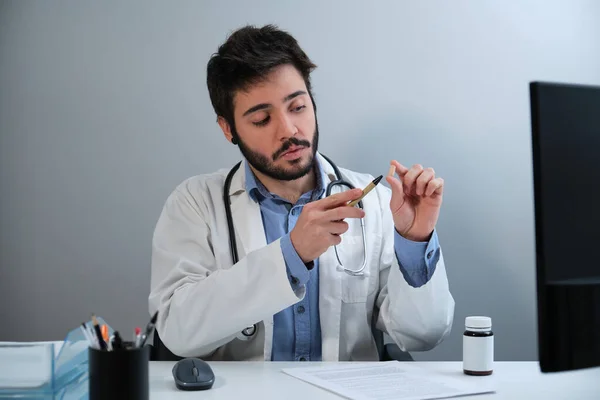 Ung läkare talar om piller sitter vid skrivbordet på läkarmottagningen. — Stockfoto
