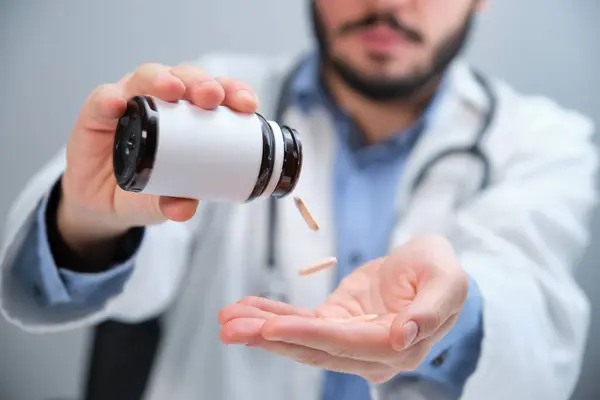 Oigenkännlig läkare hälla piller från en flaska. — Stockfoto