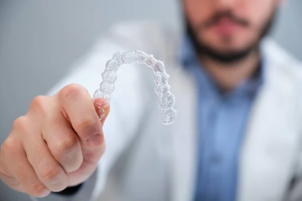 Görünmez diş hizalayıcıları tutan tanımlanamayan ortodontist.