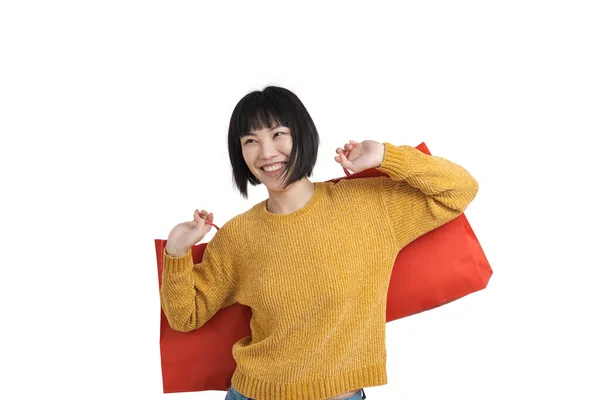 Νεαρή Ασιάτισσα χαμογελά και κρατάει τσάντες για ψώνια, απομονωμένη. — Φωτογραφία Αρχείου