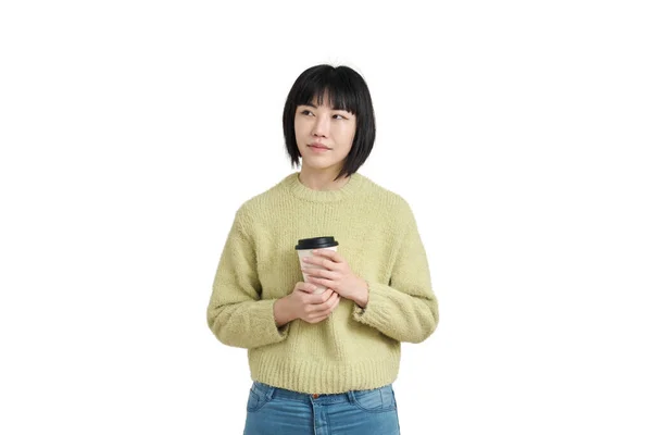 Junge asiatische Frau mit Kaffeetasse, in wintergrünem Pullover, isoliert. — Stockfoto