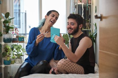 Makyöz, file çorap giyen bir adama transseksüel makyajı yapıyor..