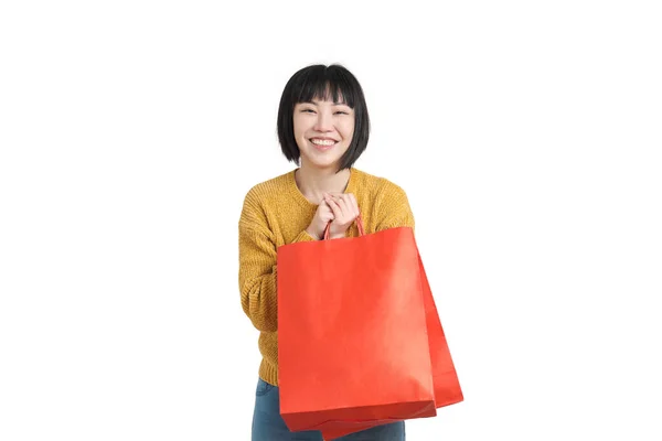 Jovem mulher asiática sorrindo e segurando sacos de compras, isolado. — Fotografia de Stock