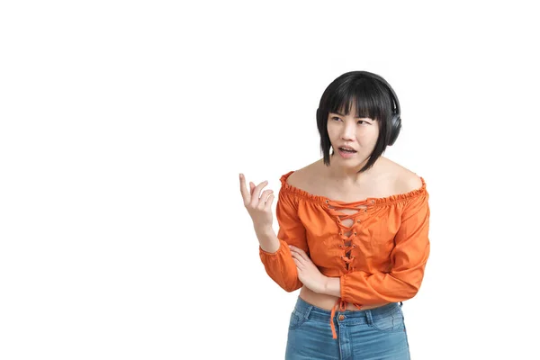 Kulaklıklı genç Asyalı kadın şaşırmış ve izole olmuş bir şeyi işaret ediyor.. — Stok fotoğraf