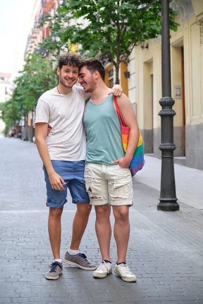 Gay coppia ridere abbracci e guardando fotocamera in il strada. — Foto Stock