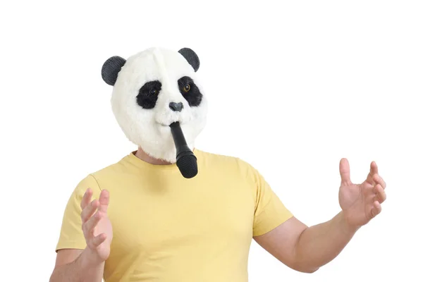 Hombre con una cabeza de máscara panda mordiendo un micrófono aislado. —  Fotos de Stock