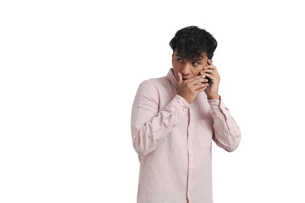 Junger peruanischer Mann flüstert am Telefon, isoliert. — Stockfoto