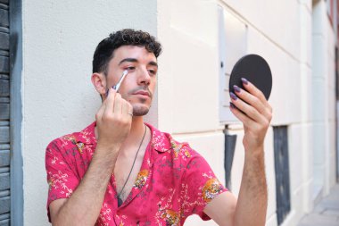 Sokakta kırmızı göz farı süren uzun takma tırnaklı beyaz bir genç..