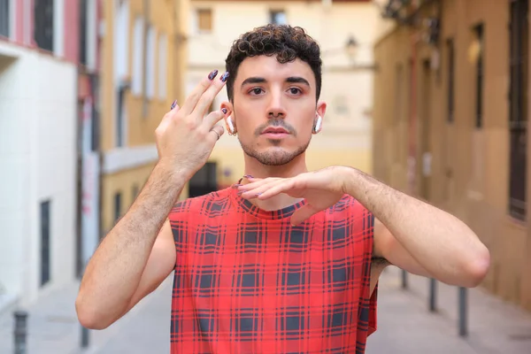 Uzun takma tırnakları olan beyaz bir adamın portresi..