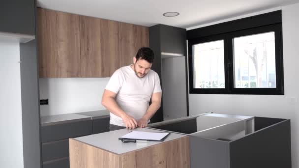 Young latin man using measuring tape before placing countertops on kitchen. — Stock Video