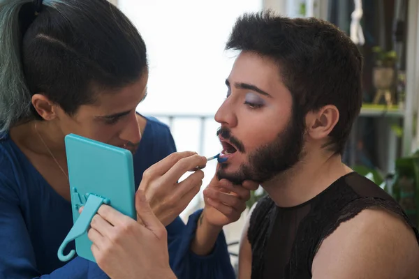 Maquillaje artista haciendo transgénero maquillaje a un hombre. — Foto de Stock