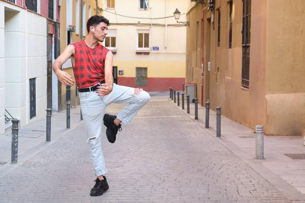 Sokakta dans eden uzun takma tırnaklı beyaz bir genç adam, modern dans..