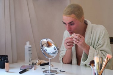 Travesti kadın makyajını çıkarıyor ve bornoz giyiyor..