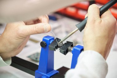 Elektronik bir bileşeni lehimleyen teknisyen tenekesi..