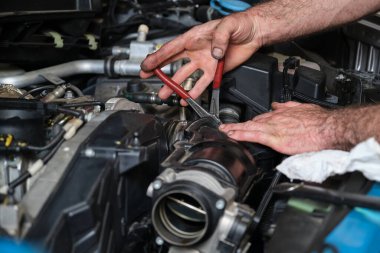 Araba tamircisi elleri, motor gazını değiştiriyor. Mekanik atölyesi.