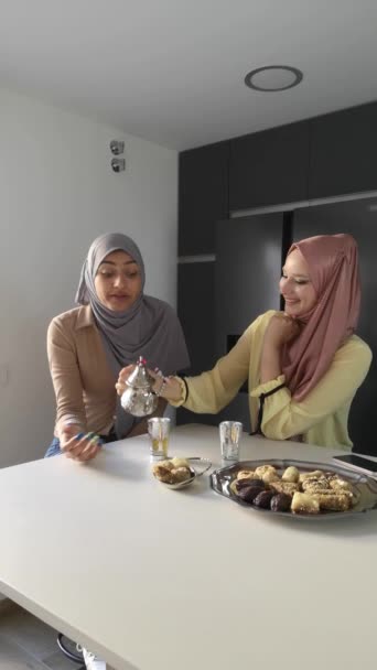 Dwie Młode Muzułmanki Serwujące Herbatę Jedzące Arabskie Słodycze Przy Stole — Wideo stockowe